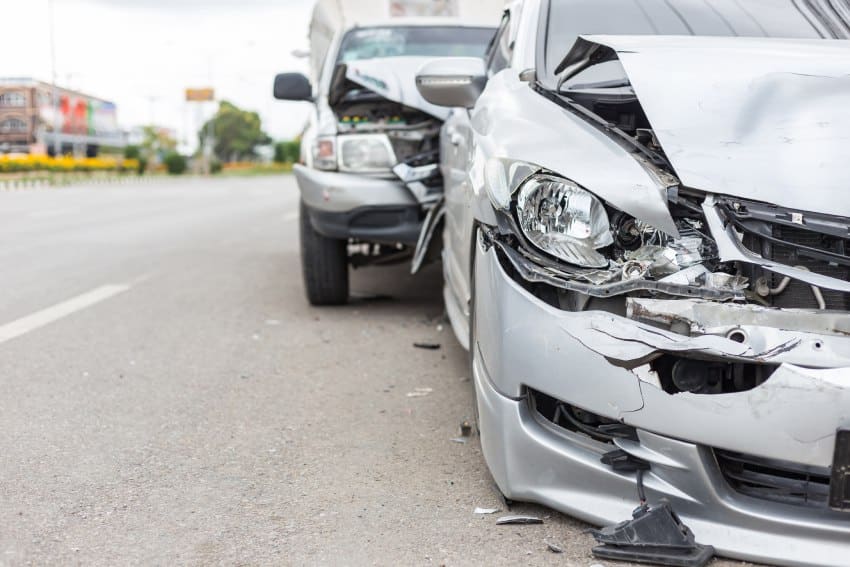 Car accident between silver car and truck front collision and rear collision debris on road