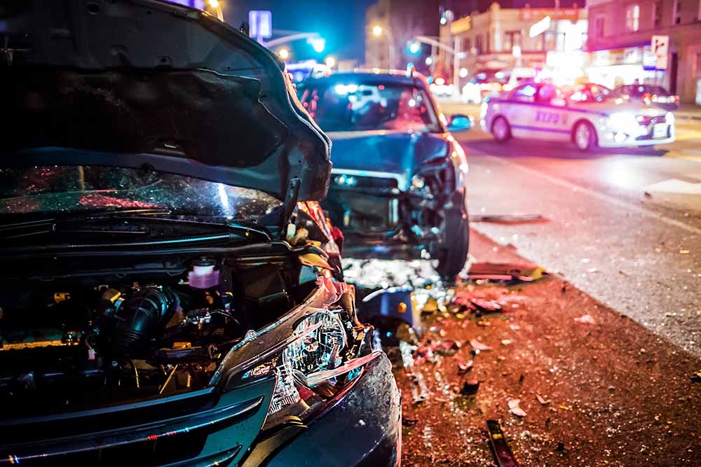 Multi-car road collision in New York City on busy road at night